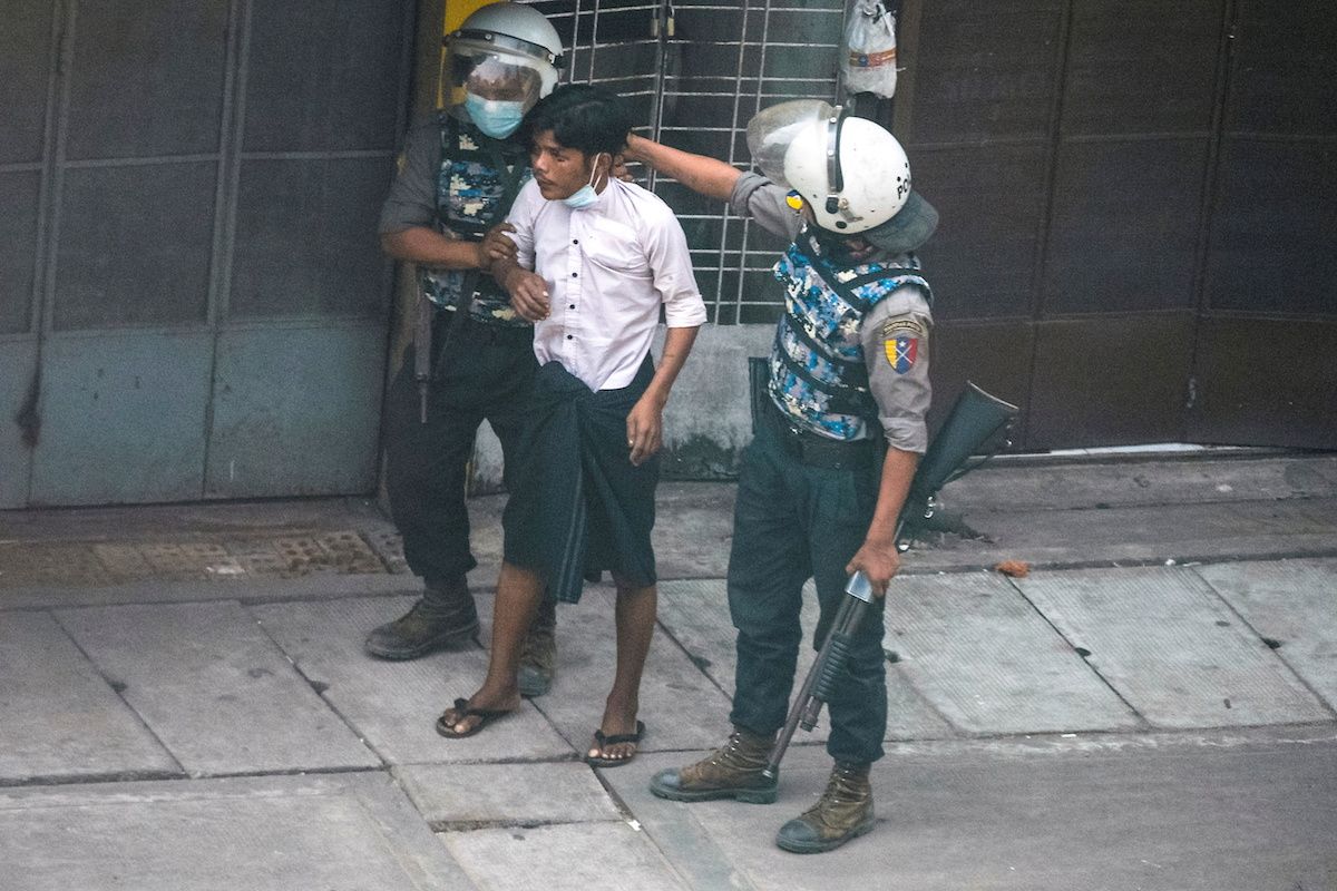 Myanmar riot police officers detain a demonstrator during a protest