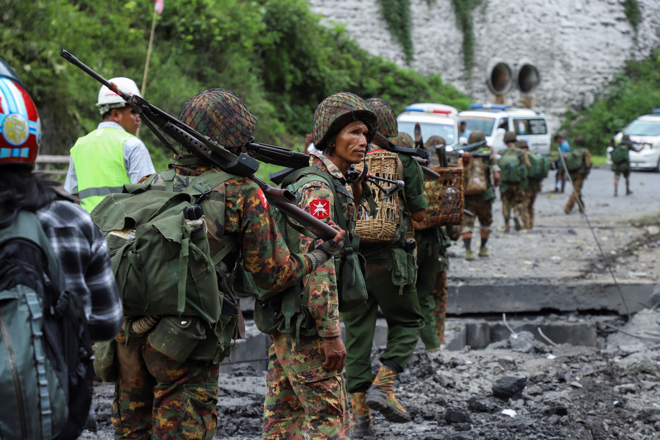 Government troops cross a bomb-damaged bridge outside the compound of the Gote Twin police station in Shan State on Aug. 15, 2019, after it was attacked by an ethnic rebel groups. (AFP photo)