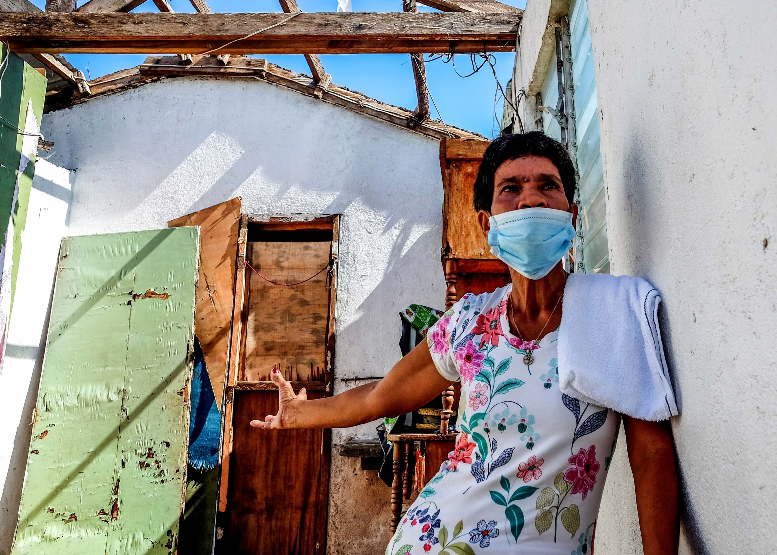 Josefina Chaveniya, 55, shows what remains of her house in the village of Baybay