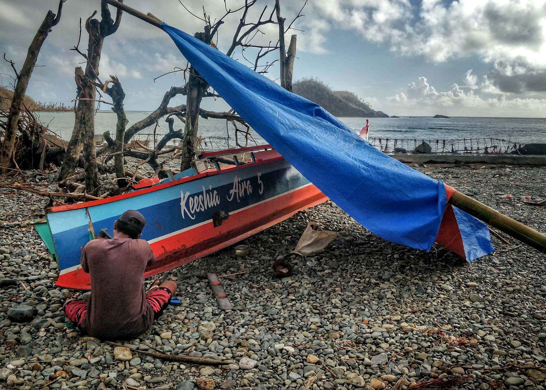 Filipino fisherman repairing his boat