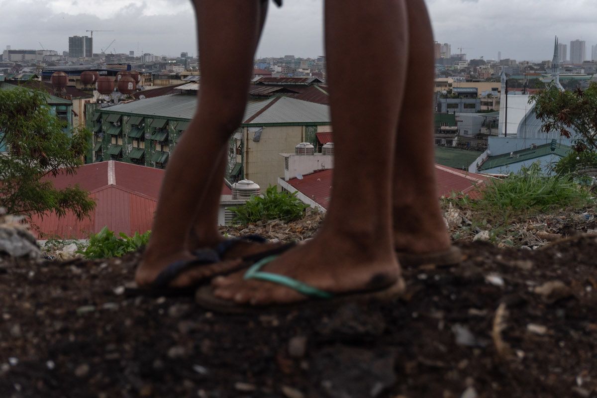 Amy and her son stand side by side outside their home at a former dump in Manila known as Smokey Mountain.