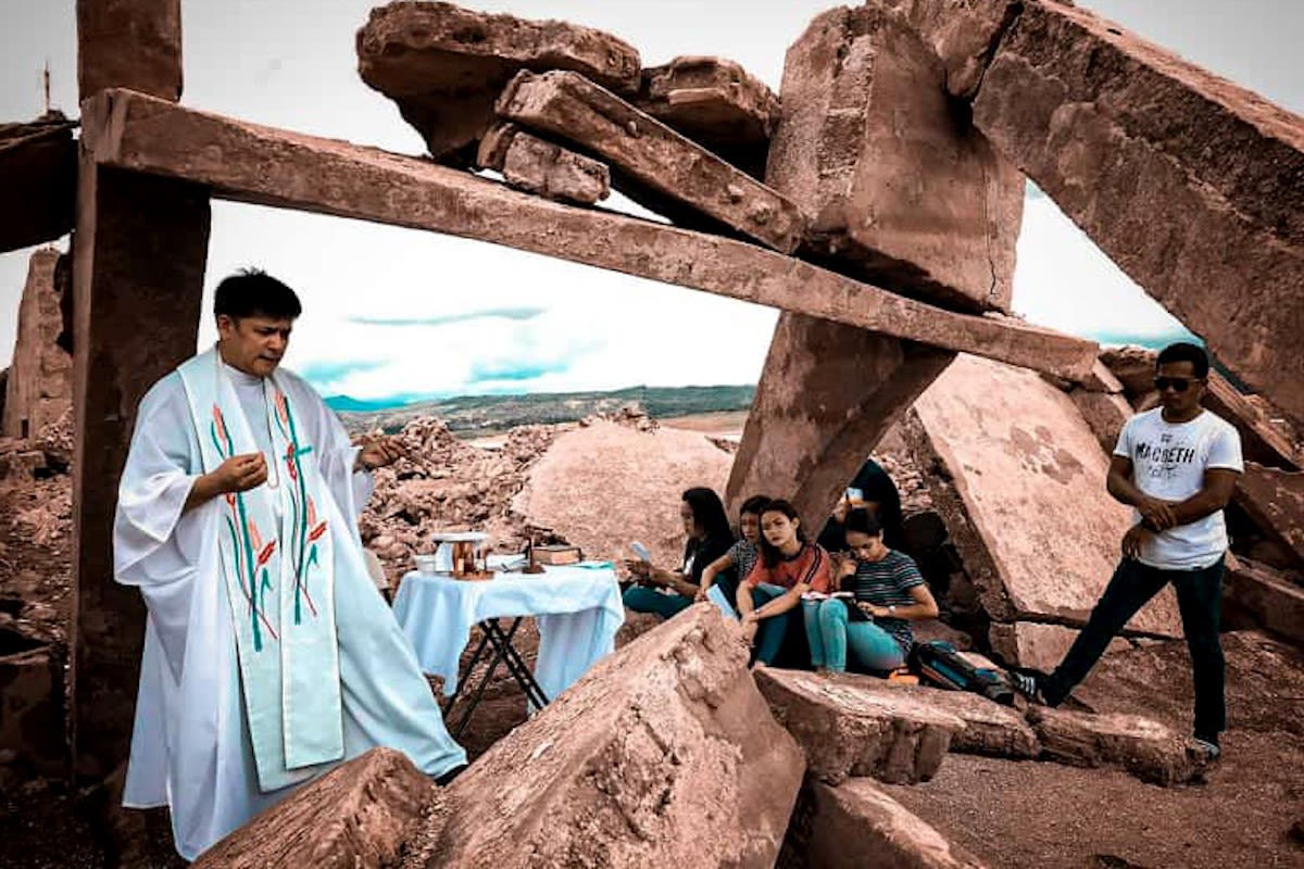 Father Arnold Abelardo, CMF, celebrates Mass at the ruins of a church in the sunken town of Pantabangan
