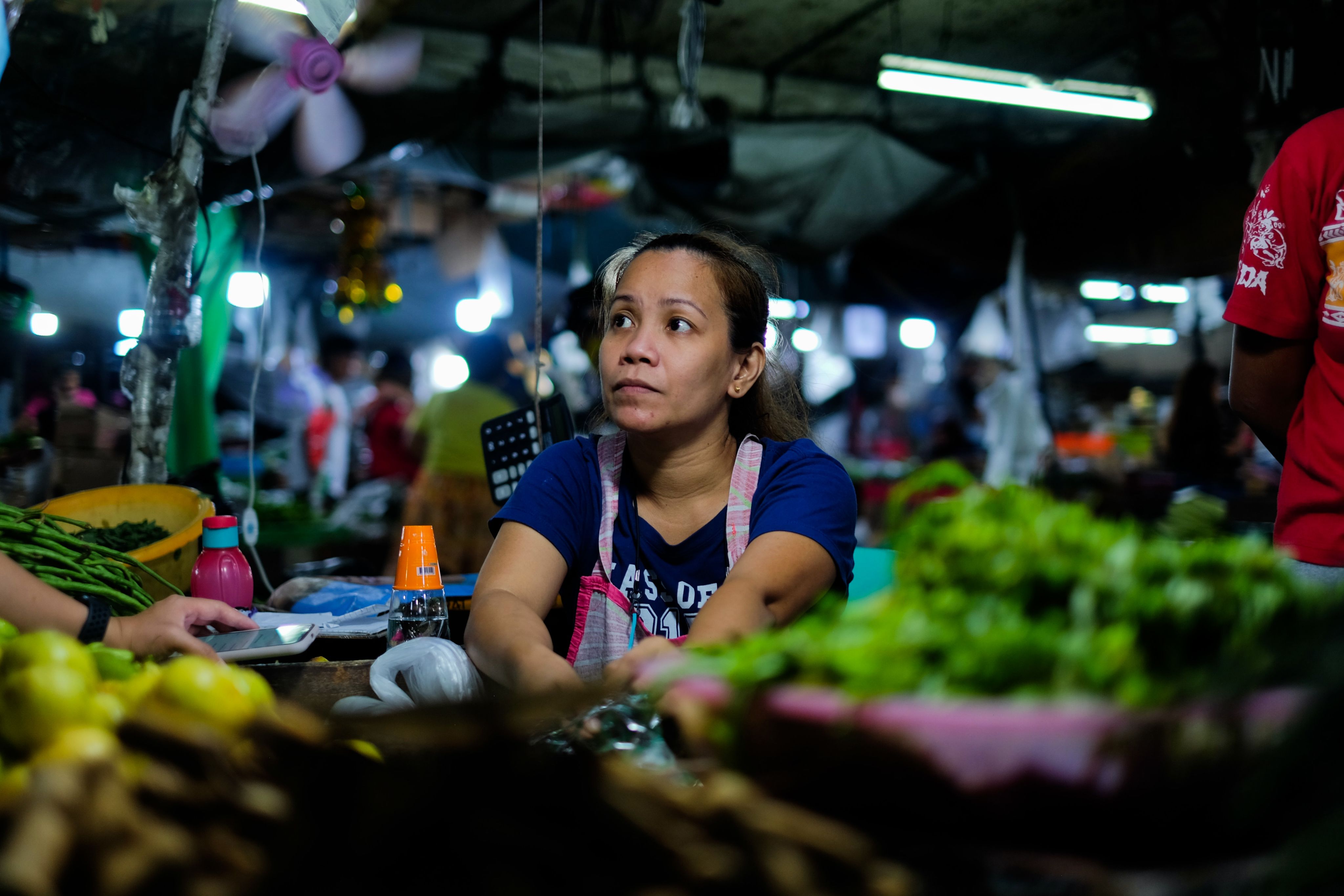 Market trader tending to her stall at a market