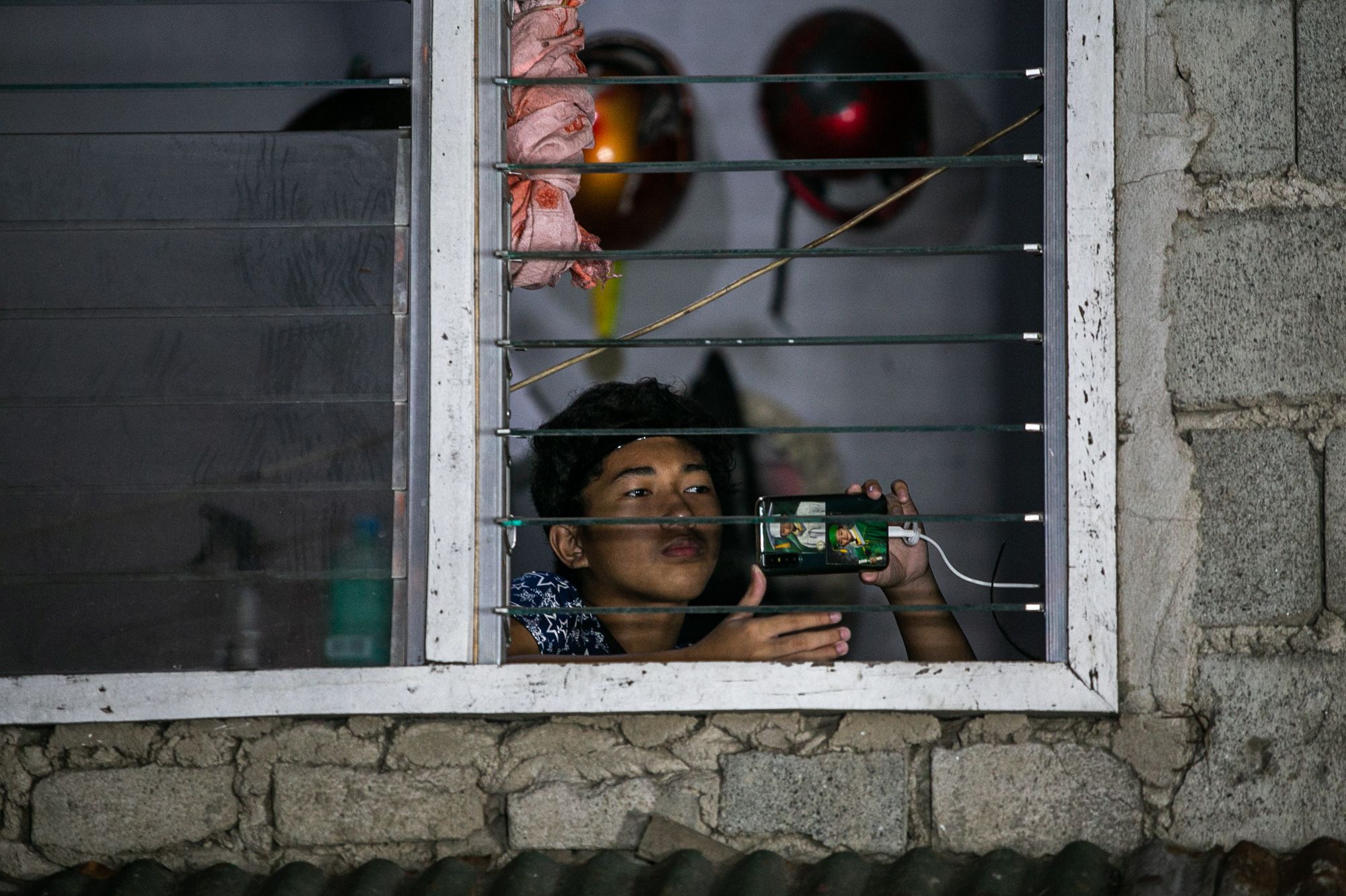 A boy takes a video of the celebration of Mass in Quezon City’s Roxas district.