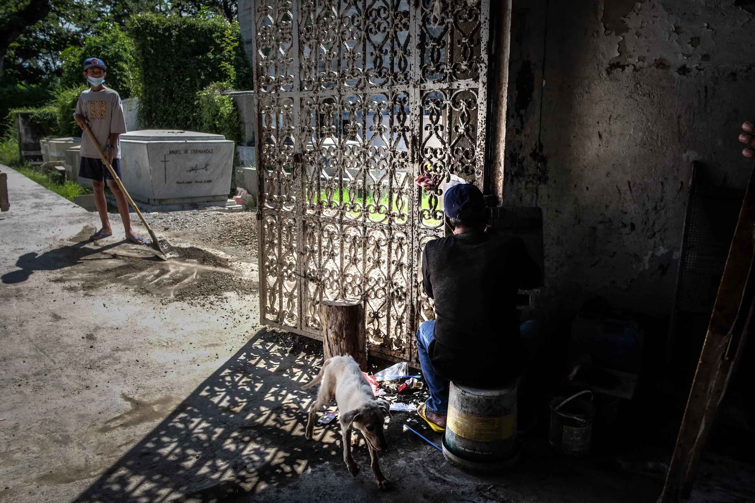 A worker prepares a tomb inside the chapel at the Catholic cemetery in Dagupan City.