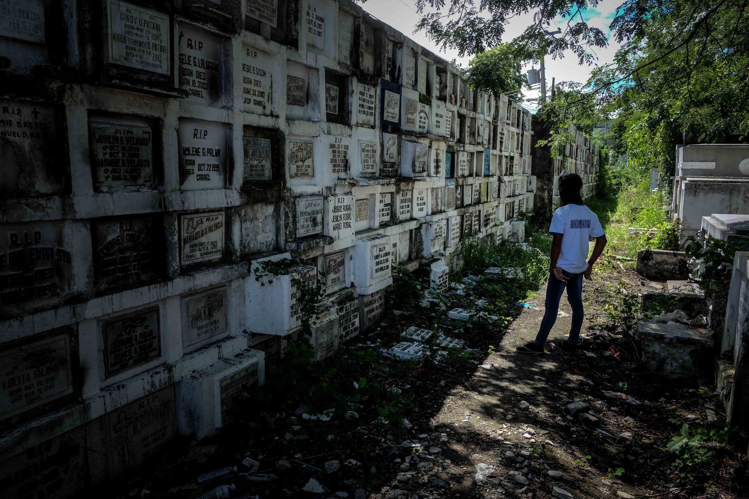 A man stands alone as a relative is being interred at the Catholic cemetery in Dagupan City.