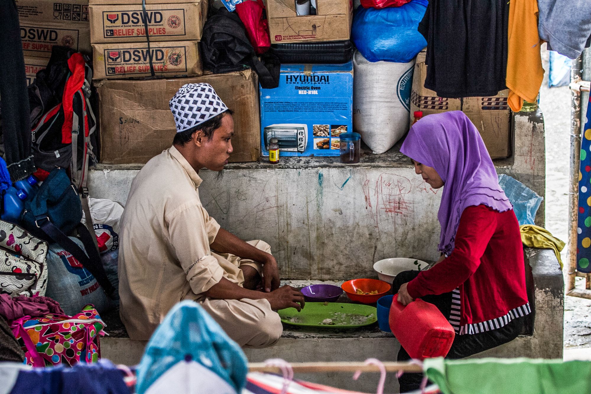 A couple who has been displaced by the Marawi conflict share a meal.