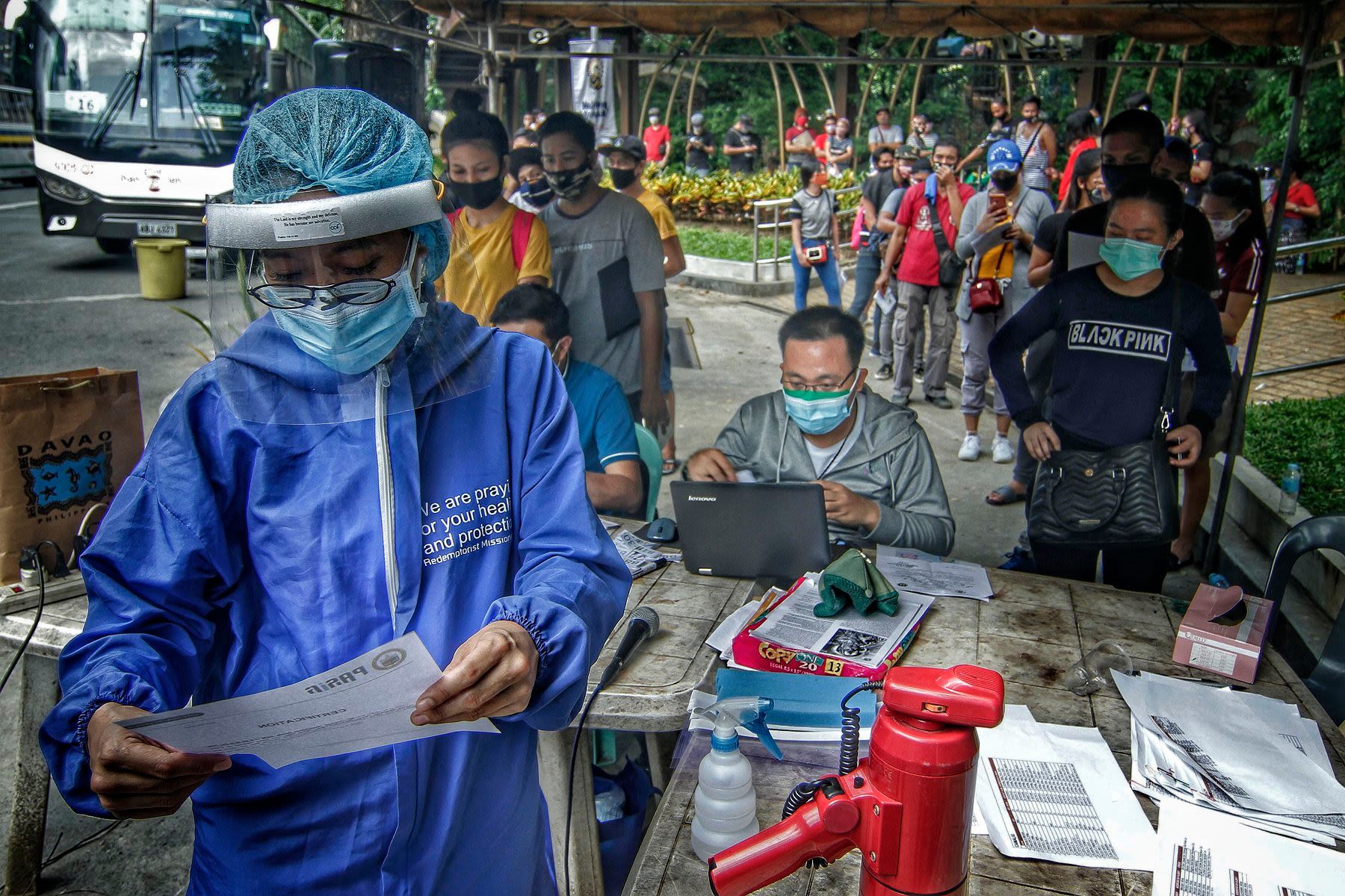 Before boarding the buses, the travellers have to undergo several health and disinfection procedures. (Photo by Vincent Go)