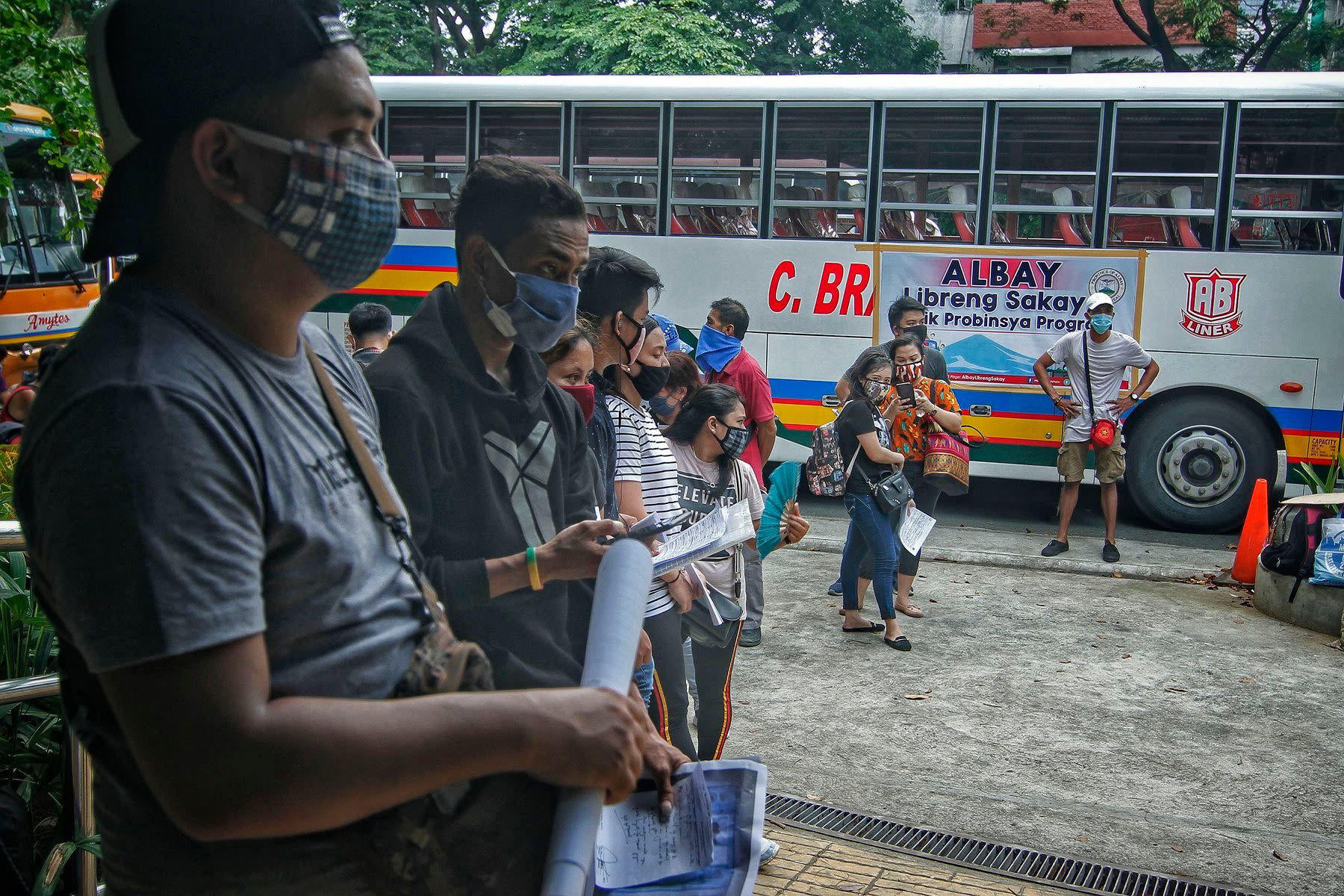 The travellers wait for their turn to be tested for the new coronavirus disease before they are allowed to board the buses. 