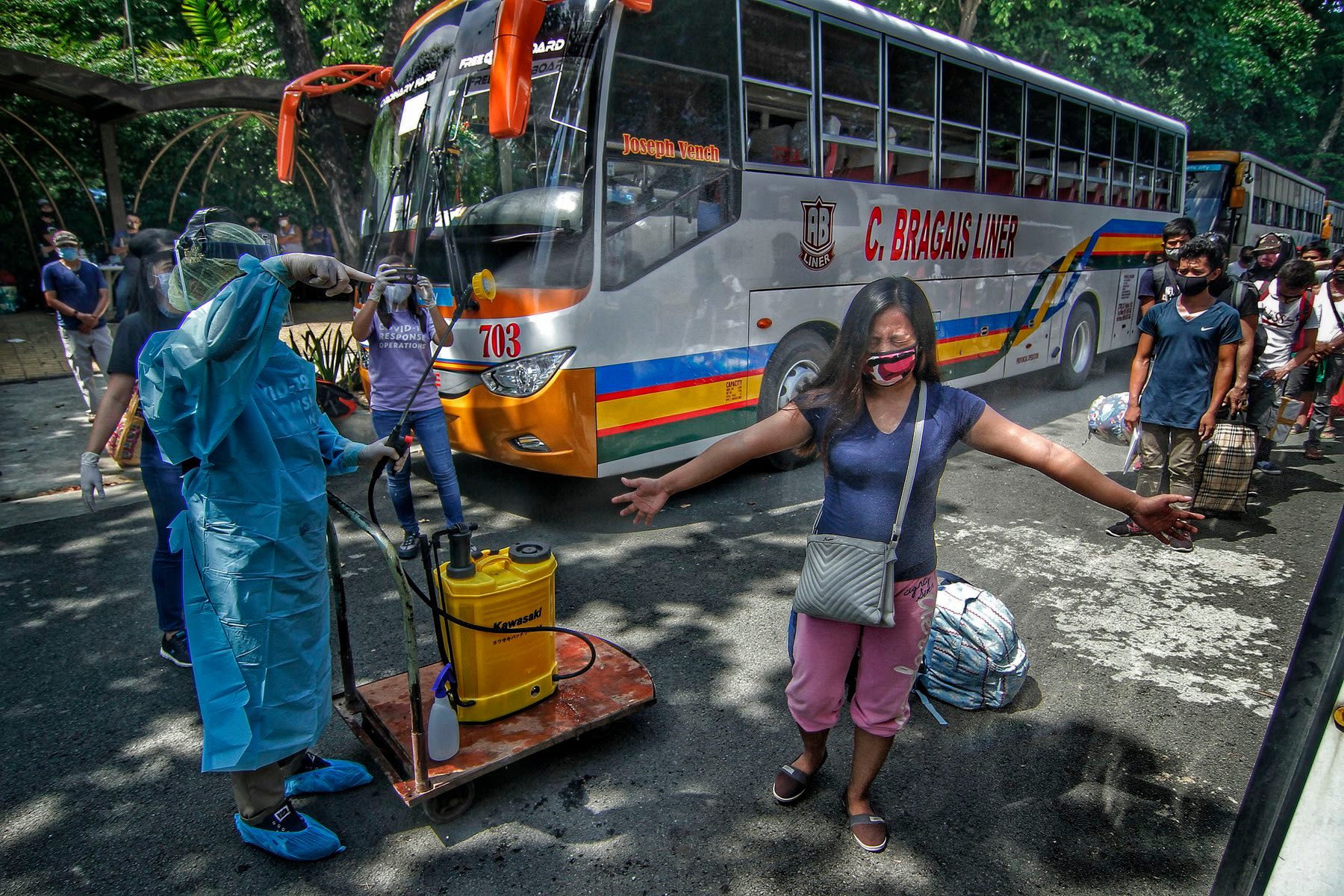 Passengers have to be disinfected before boarding the buses that would take them home to Albay province on June 5.