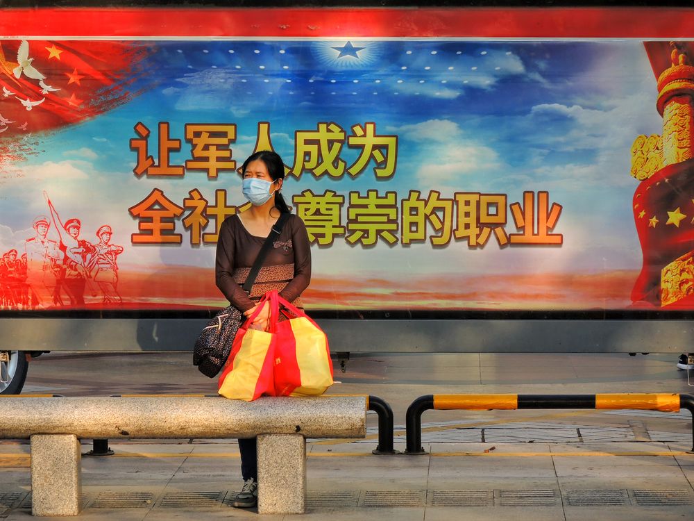 A woman waiting at a bus stop in Huizhou, China. (shutterstock.com photo)