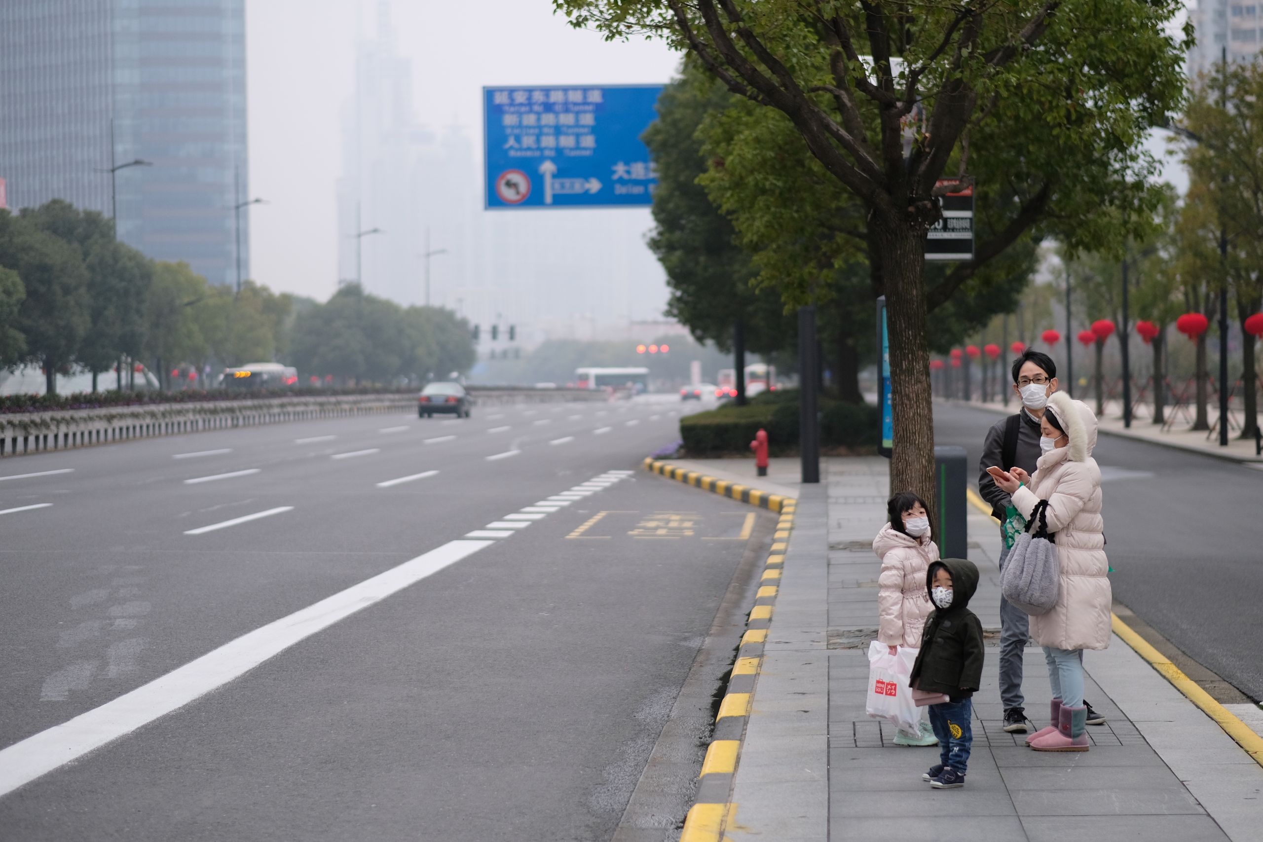 A family wearing mask wait at bus station in Shanghai, China sometime in January. (shutterstock.com photo)