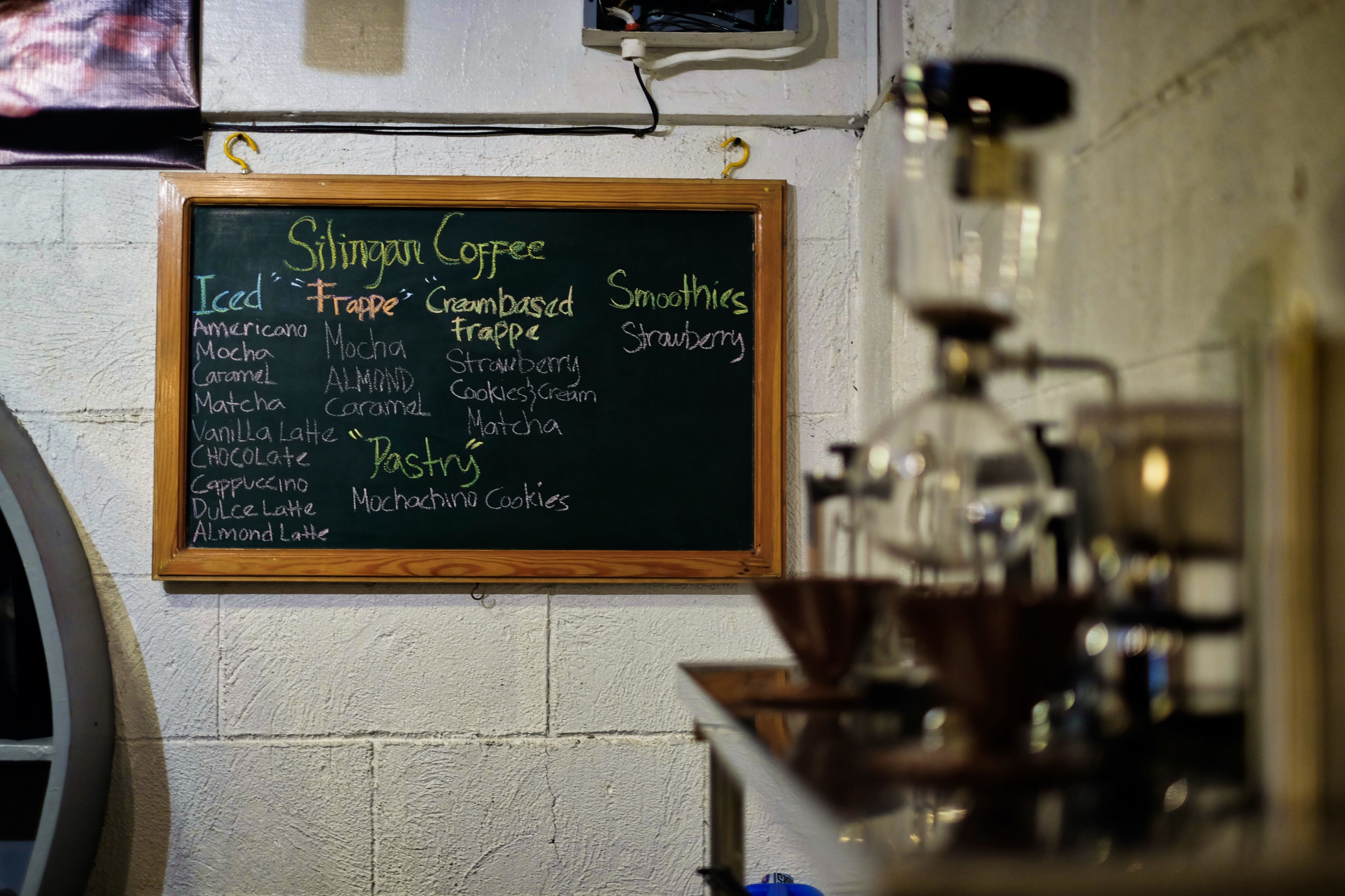 Drinks menu on black chalkboard in a coffee shop