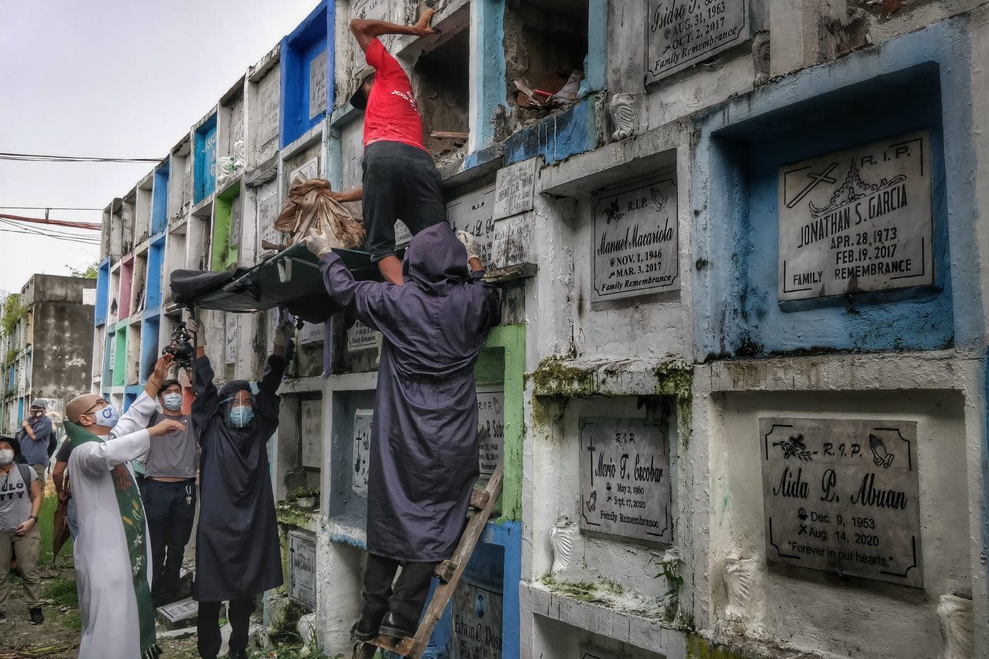 Catholic priest helping exhumation of remains in a cemetery in Manila, Philippines