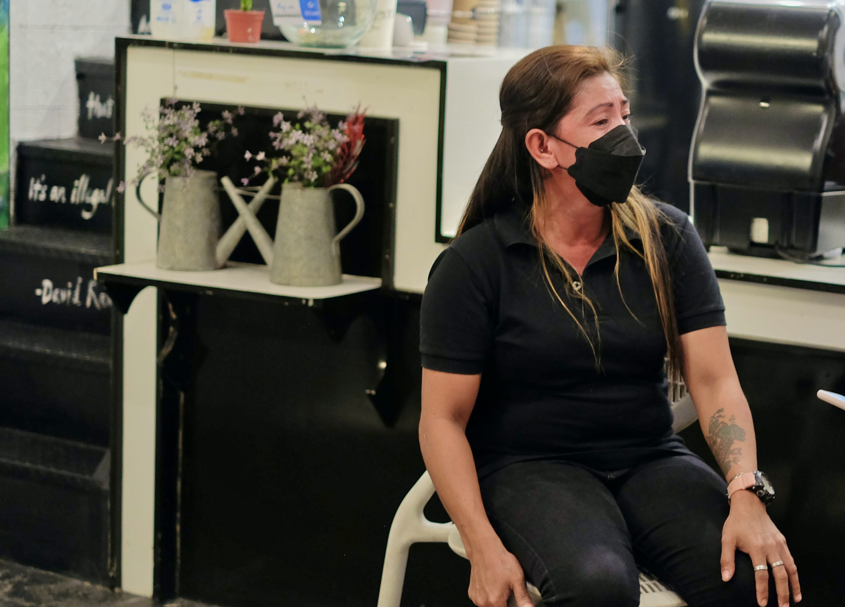 A woman dressed in black sitting on a chair