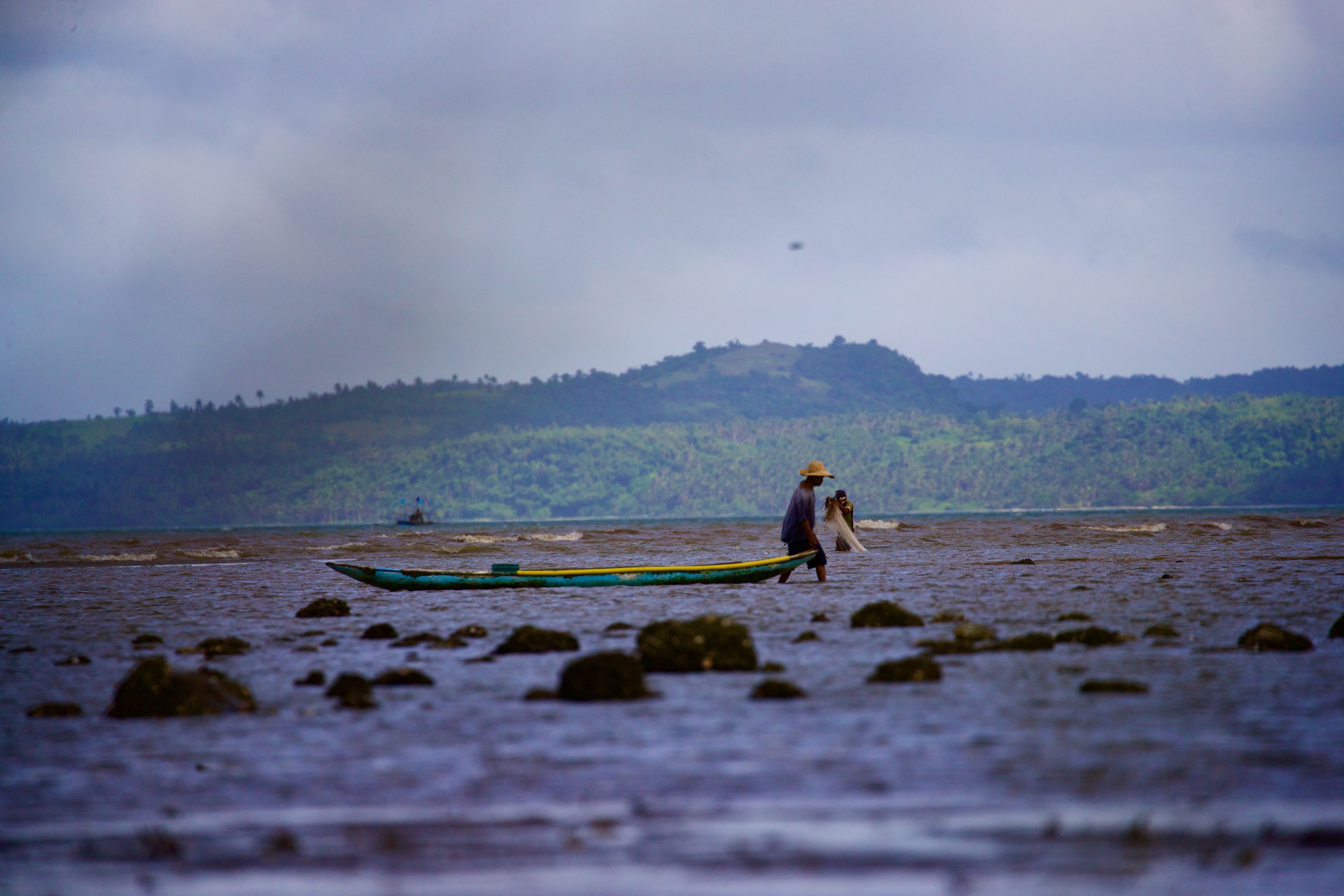 Fisherman pulling boat by the shore