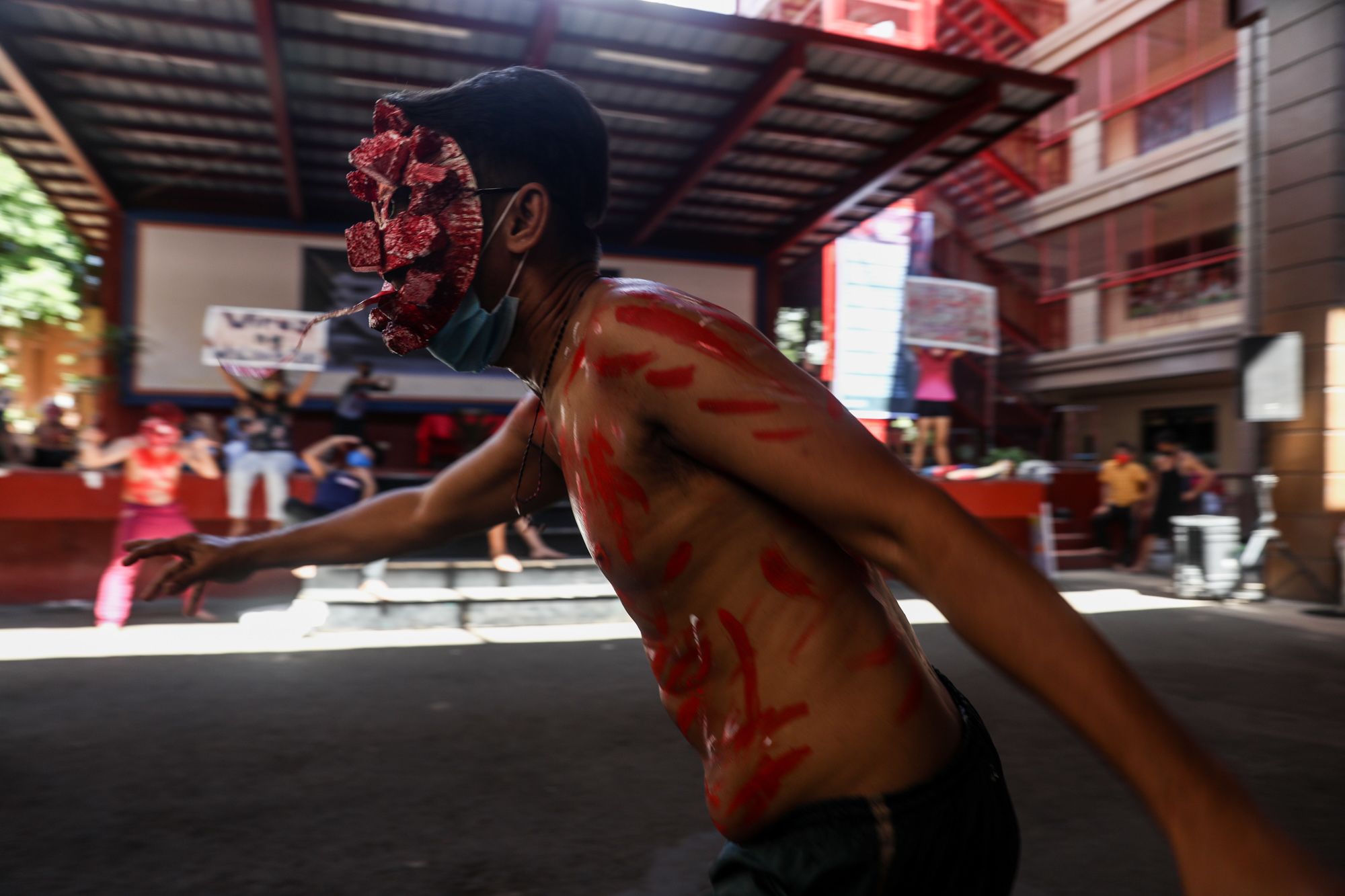 A performer wears a mask depicting COVID-19 during the play inside the Paco Catholic School in Manila.