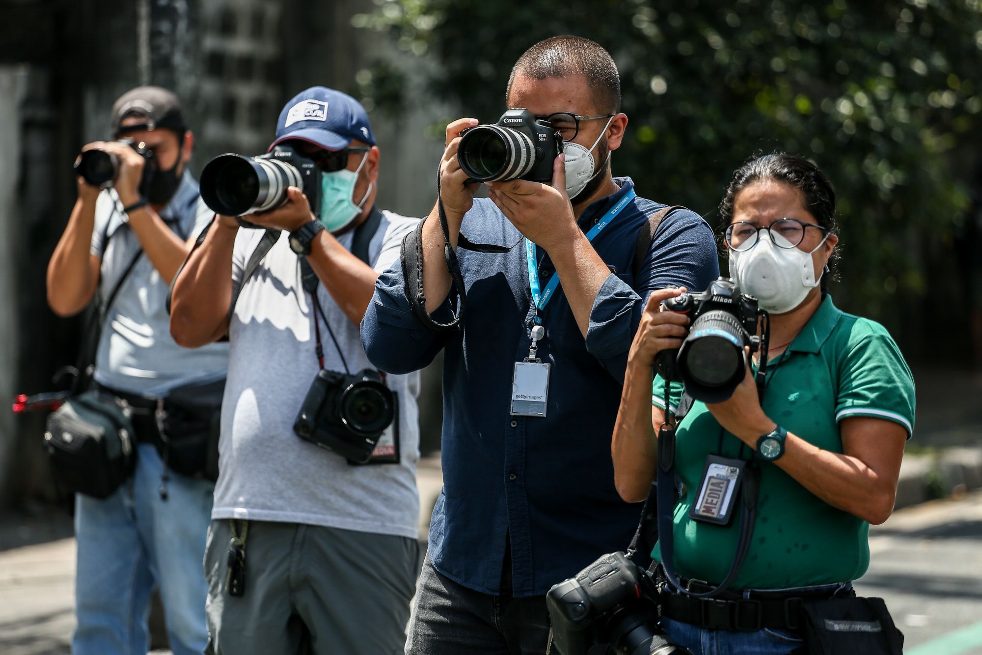 Photojournalists take photos of a workers disinfecting the streets of the Philippine capital. (Photo by Basilio Sepe)