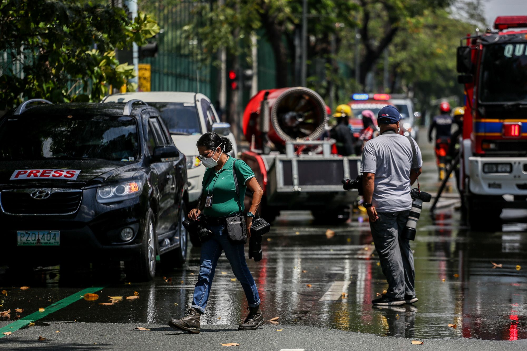 Photojournalists wearing protective masks walk on the street of Manila during a misting operation. (Photo by Basilio Sepe)