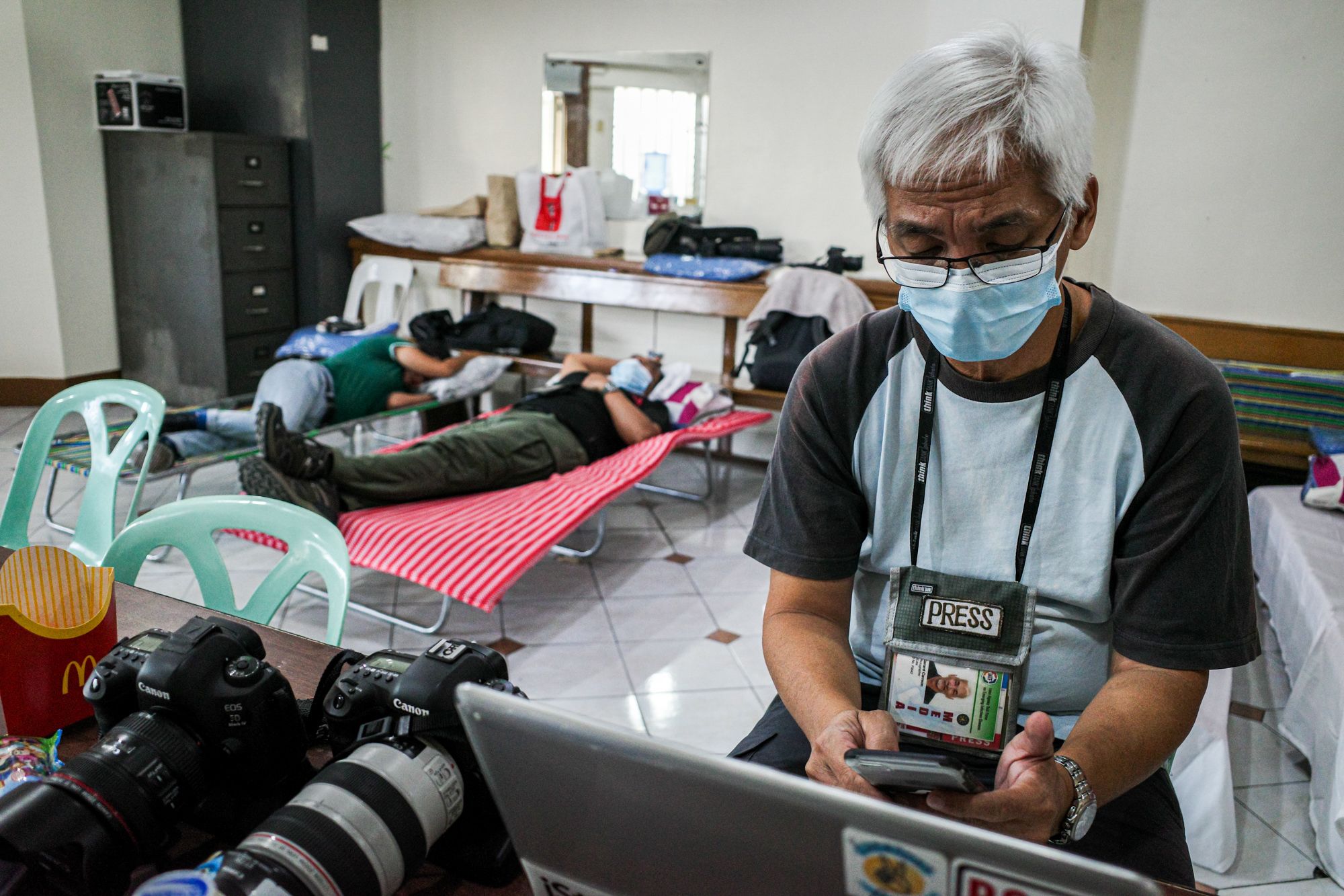 Photojournalists Gerard Carreon, Maria Tan, and Angie de Silva seek temporary sanctuary in the basement of a parish church in Quezon City. (Photo by Mark Saludes)