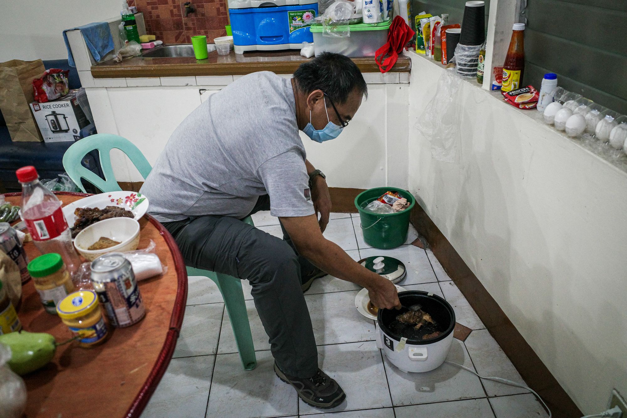 Photojournalist Angelo de Silva cooks food in the basement of a church in Manila where he and his colleague sought shelter. (Photo by Mark Saludes)