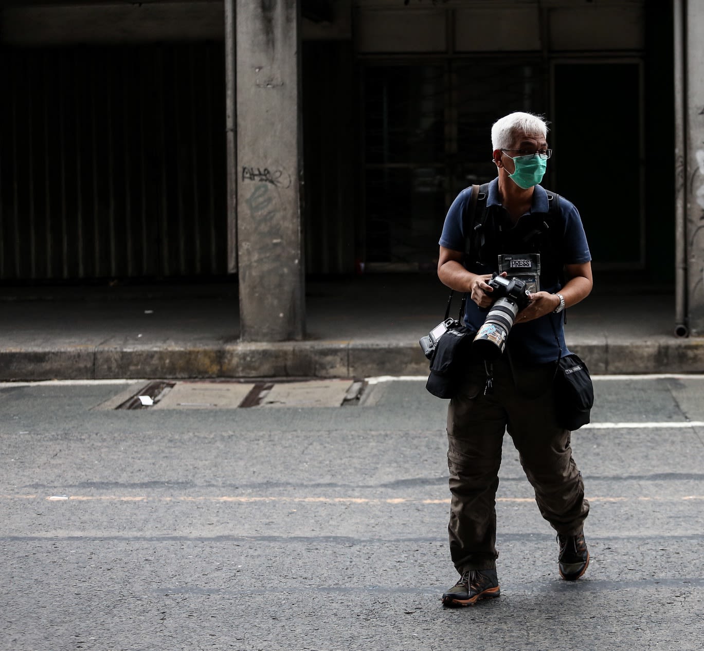 Photojournalist Gerard Carreon crosses a street in Manila during coverage of the lockdown in the Philippine capital. (Photo by Basilio Sepe)