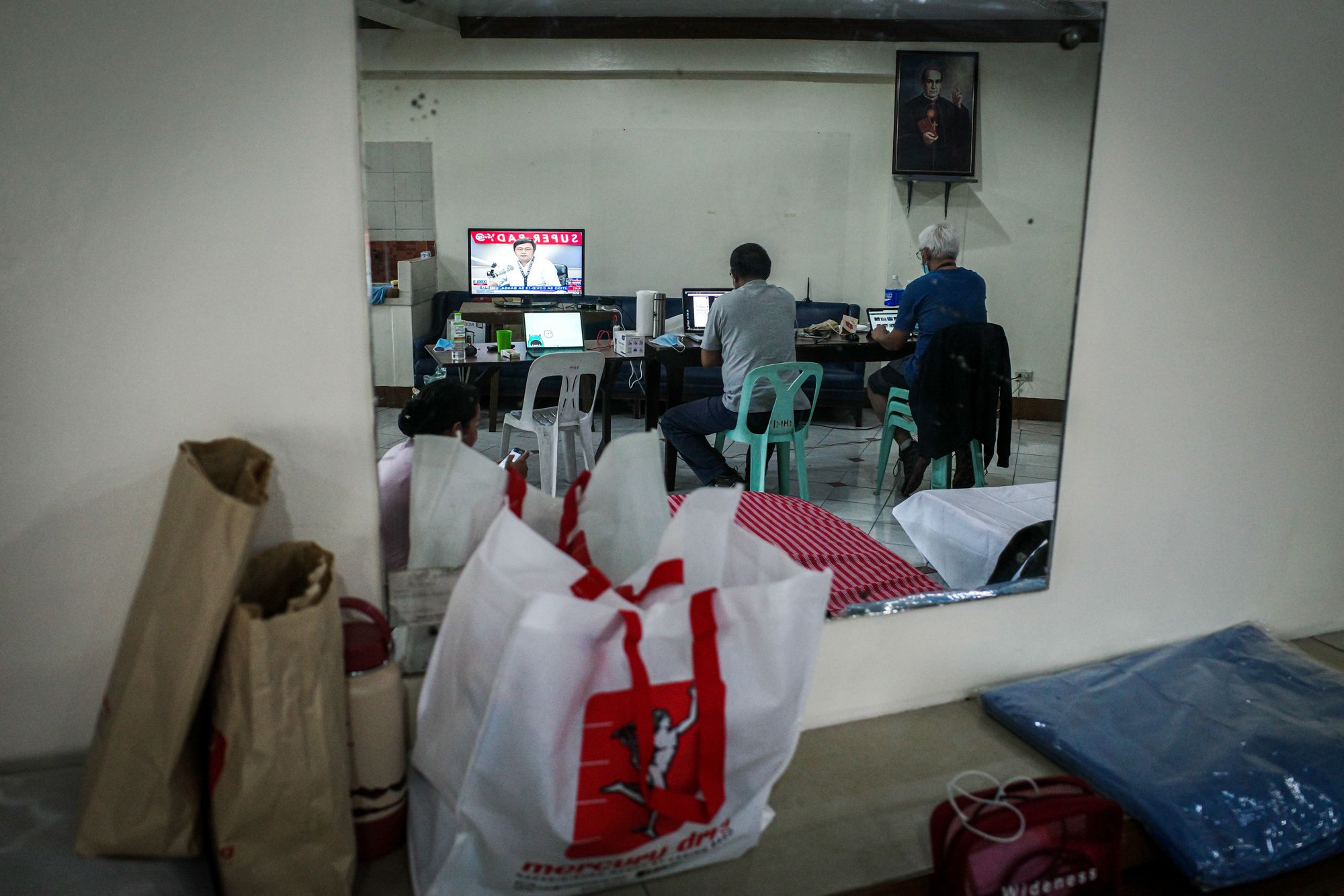Angie de Silva and Gerard Carreon takes time to watch television while not taking pictures outside during the lockdown. (Photo by Mark Saludes)