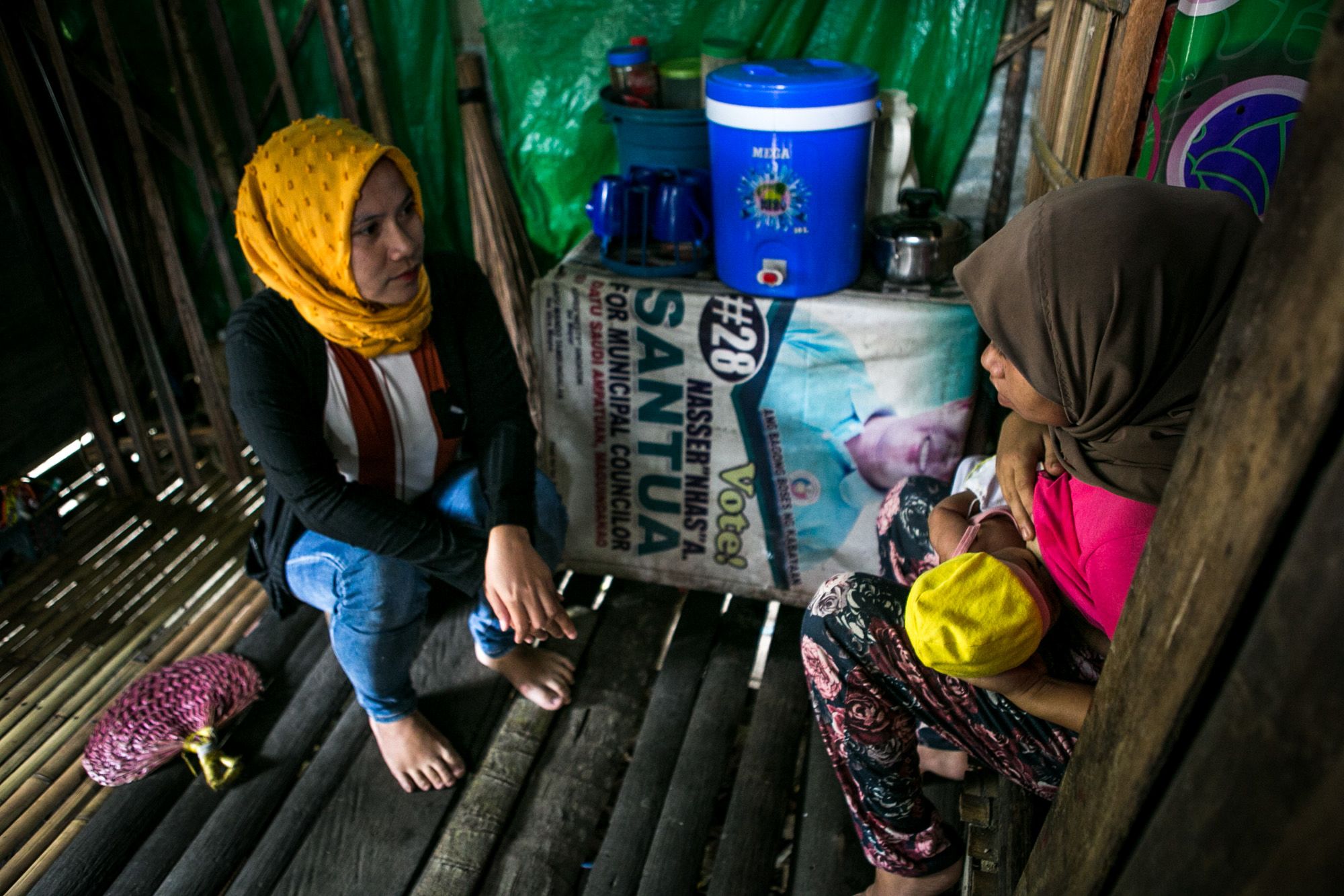 Social worker Noraja Suib of the United Youth of the Philippines-Women Inc. talks to Baimanot, a young mother whose marriage was arranged by her parents last year.