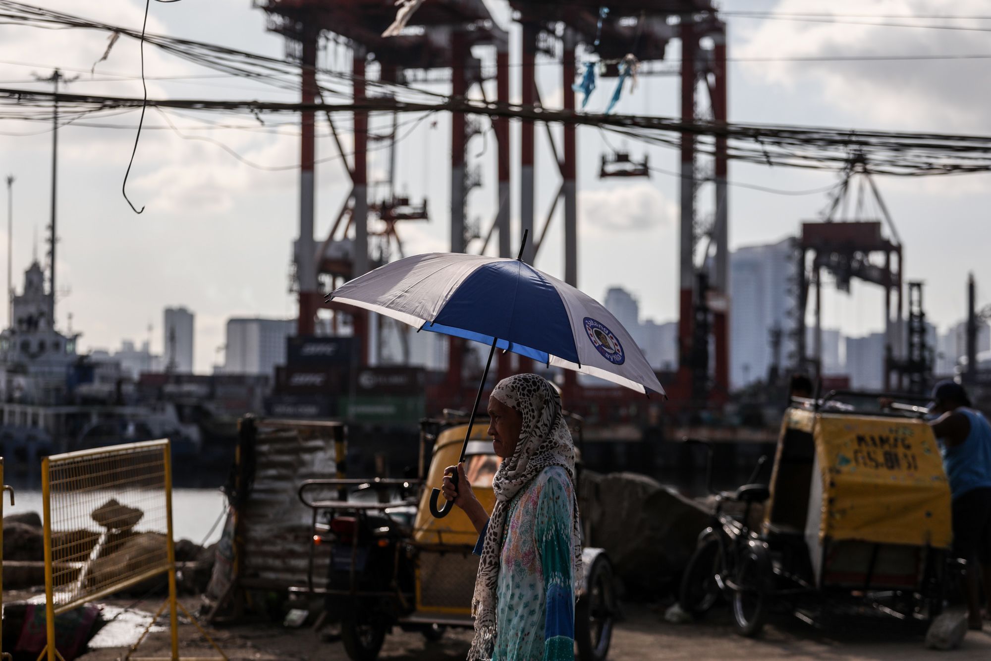 A resident of Baseco compound, a poor district near the port of Manila, takes a walk under the heat of the sun. (Photo by Basilio Sepe)