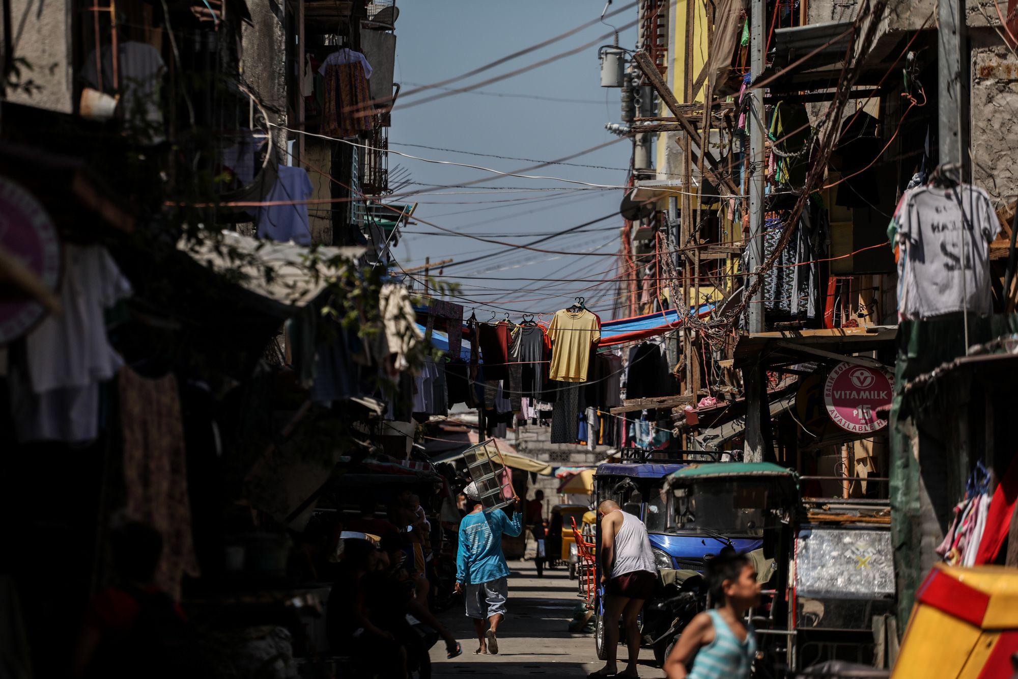 People walk below tangled electricity lines inside Baseco compound in Manila, Philippines.