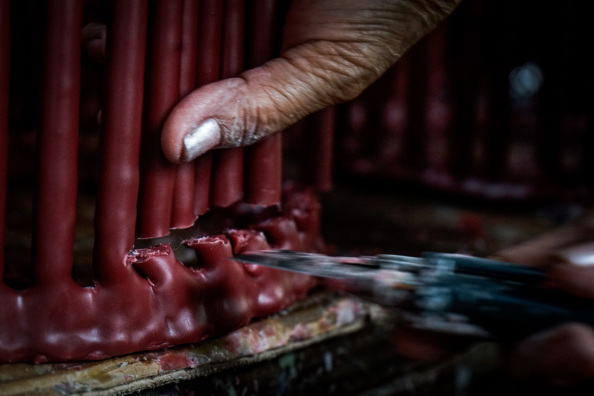 While still warm, the new candles are cut from the mold.