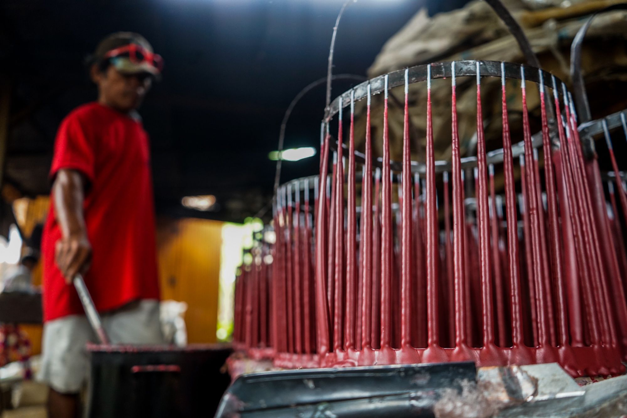 Alfredo Dellagado lets the candles cool, then refills the container with molten wax for another set of candles.