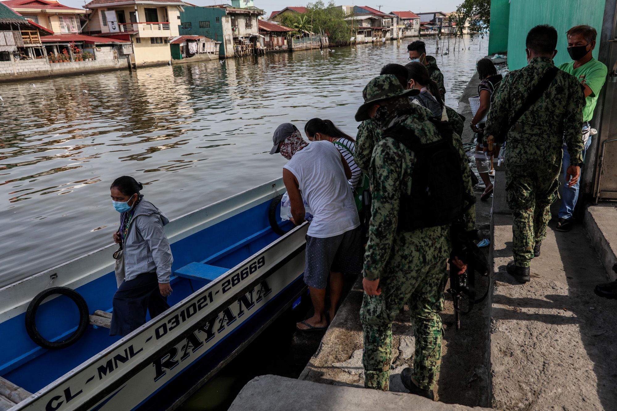 Government workers board a small boat in the Philippines