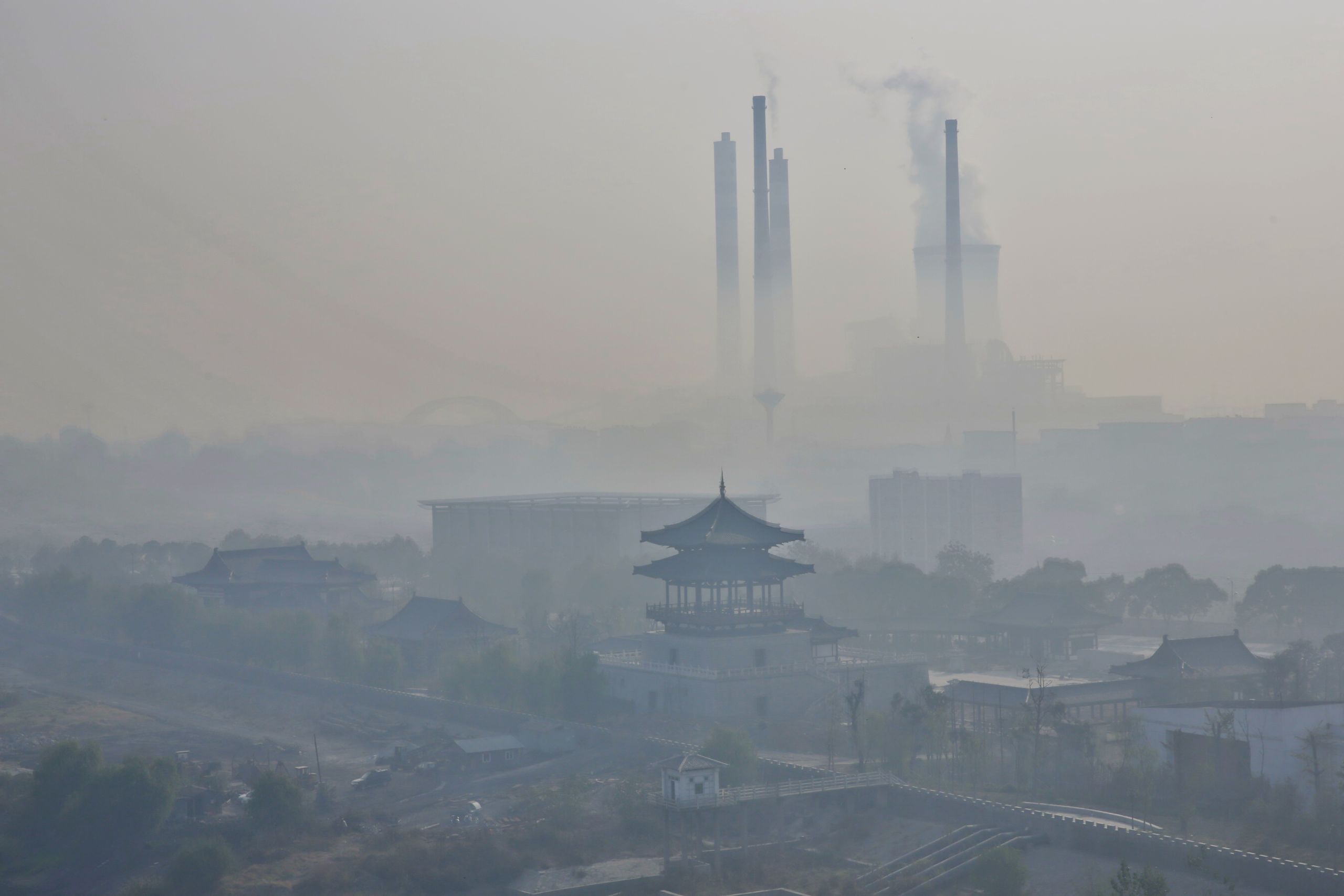 Severe fog and haze, power plants are the big chimney emissions along the Yangtze River in the eastern Chinese city of Jiujiang. (Photo by humphery / Shutterstock.com)