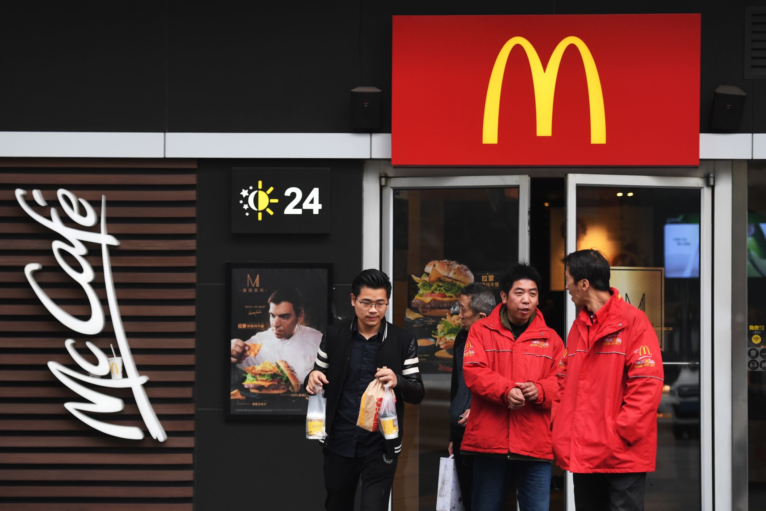 People stand outside a McDonald's restaurant in Beijing on Oct. 26, 2017. (Photo by Greg Baker/AFP)