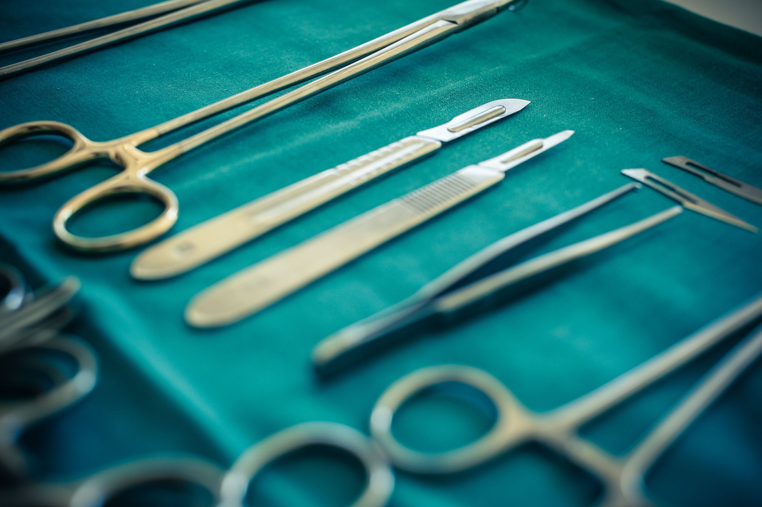 surgical instruments and tools including scalpels, forceps and tweezers arranged on a table for a surgery